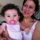 Imagem da Carminda, usuária do implante coclear, com a Joana bebê futura implantada no colo