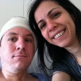 Imagem de Lak (sorrindo para a câmera) e Marcelo, com seu curativo em forma de turbante que protege a orelha do lado em que foi inserido o Implante Coclear.